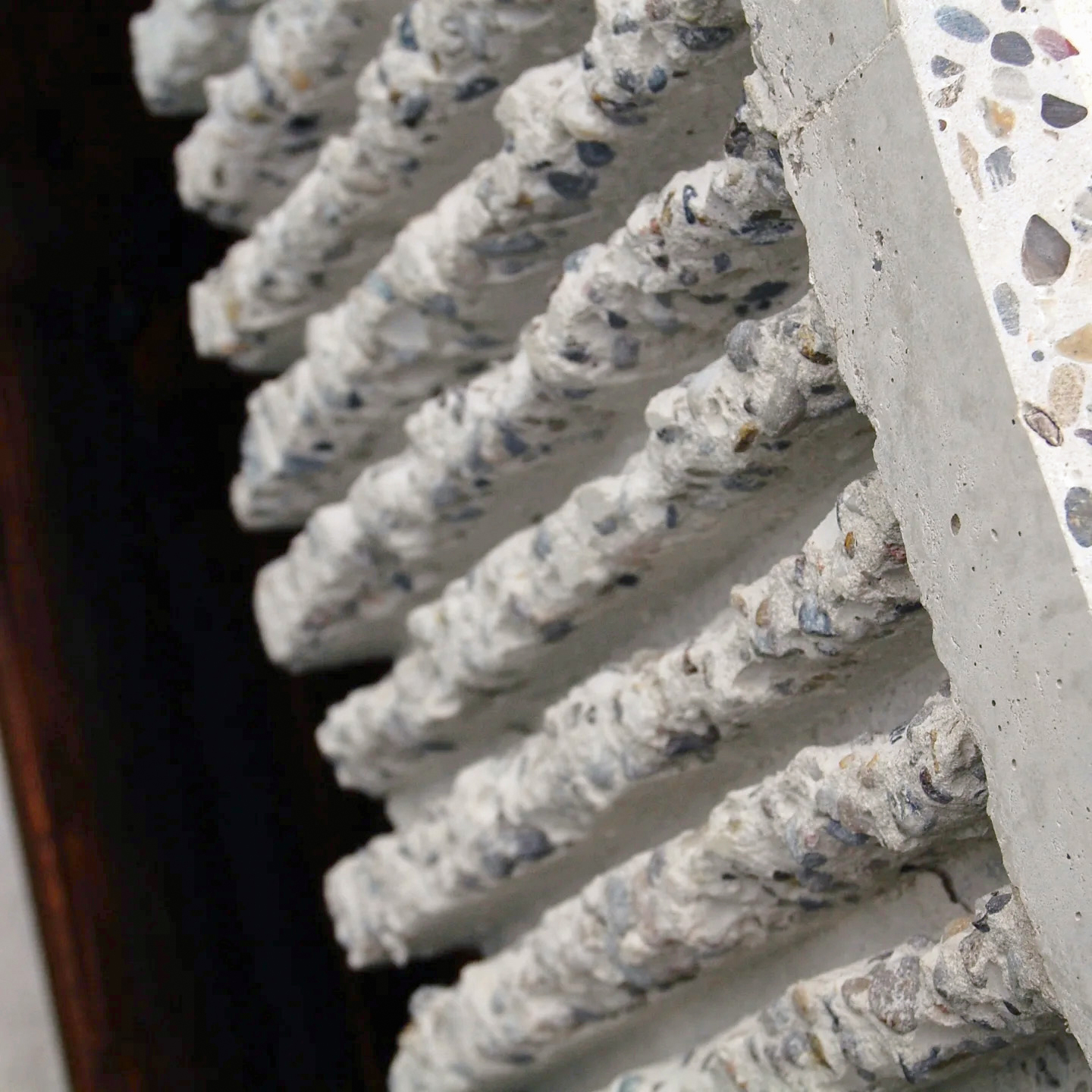 Close-up of the chipped concrete edge with wooden shelf